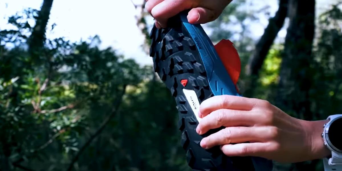 Close-up view of a trail running shoe outsole with deep lugs